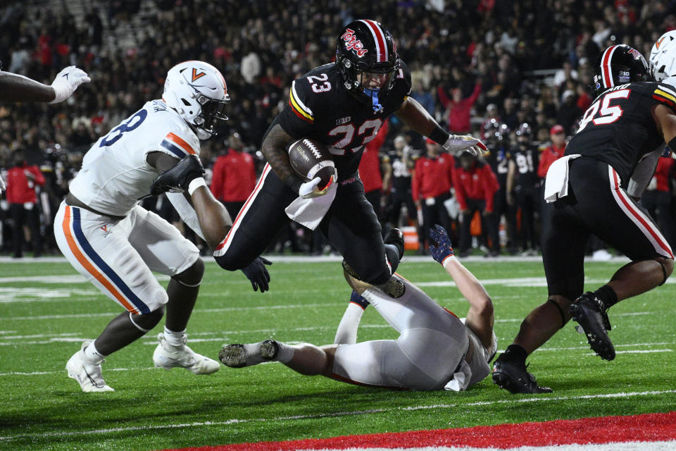 Maryland running back Colby McDonald (23) dives toward the end zone, for a touchdown past Virginia defensive tackle Michael Diatta, left, during the second half of an NCAA college football game Friday, Sept. 15, 2023, in College Park, Md. (AP Photo/Nick Wass)