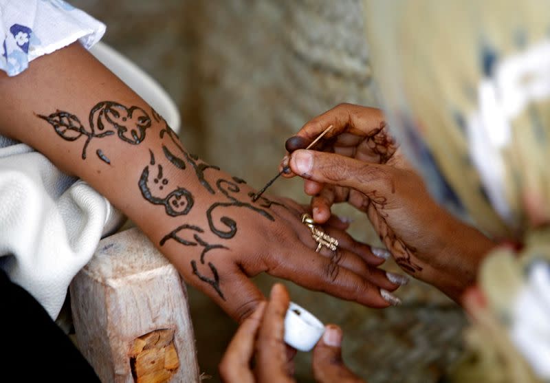 Local women paint each other with henna in Lamu