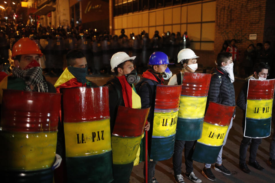 Demonstrators with makeshift shields protest against President Evo Morales' reelection, in La Paz, Boliva, Wednesday, Nov. 6, 2019. Opponents challenged an official count that showed Morales winning with 47% of the vote and a margin of just over 10 percentage points over his nearest competitor, enough to avoid the need for a runoff against a united opposition. (AP Photo/Juan Karita)