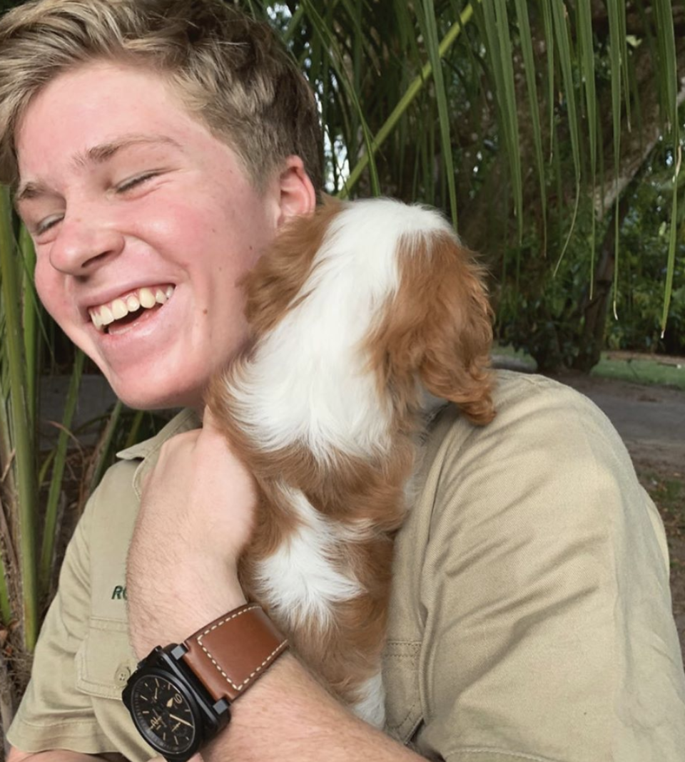 Rob Irwin holding Bindi Irwin and Chandler Powell's new puppy named Piggy.