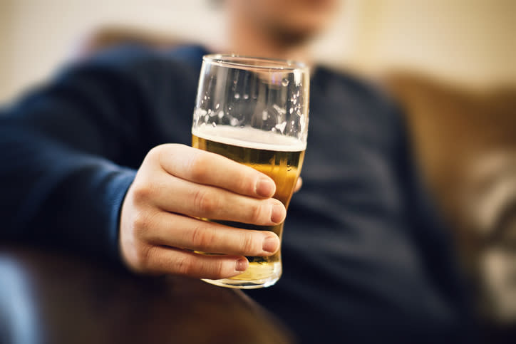 A man is pictured holding a pint of beer.