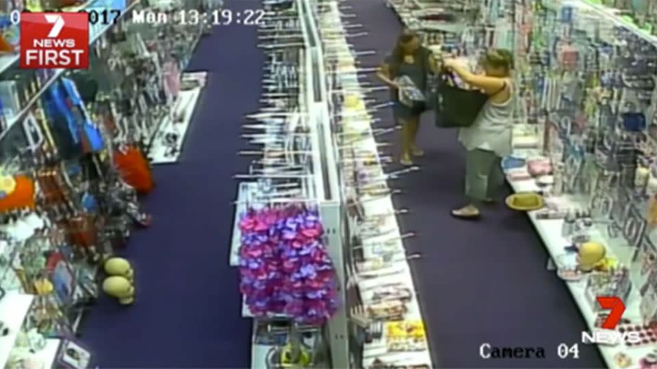 The moment the women begin stuffing items inside the bag. Source: 7 News