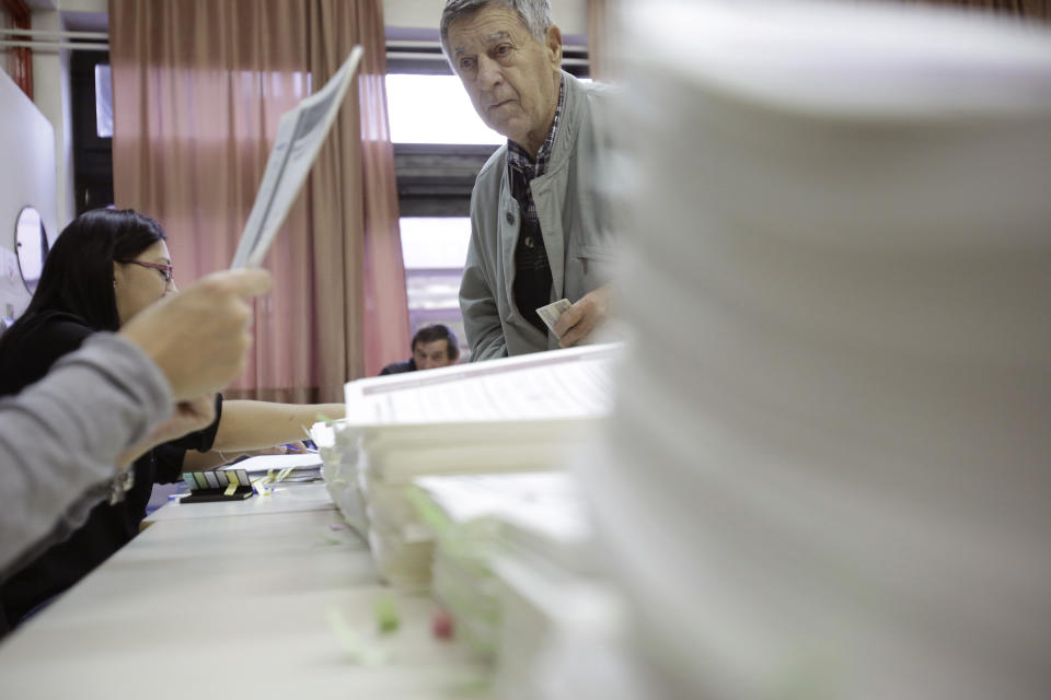 Bosnian man show his ID as he prepare to cast his vote at poling station in Sarajevo, Bosnia, on Sunday, Oct. 7, 2018. Polls have opened in Bosnia for a general election that could install a pro-Russian nationalist to a top post and cement ethnic divisions drawn in a brutal war more than 20 years ago. Sunday's vote is seen as a test of whether Bosnia will move toward integration in the European Union and NATO or remain entrenched in war-era rivalries. (AP Photo/Amel Emric)