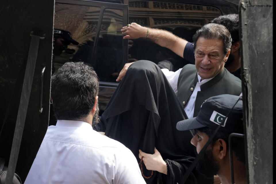 Pakistan's former Prime Minister Imran Khan, right, with his wife Bushra Bibi, center, arrive to appear in a court in Lahore, Pakistan, Monday, June 26, 2023. Khan faces more than 100 legal cases, including on graft charges during his 2018-2022 term as premier, and has also been charged with terrorism for inciting people to violence. In court, he has won protection from arrest in multiple cases, pending trial. (AP Photo/K.M. Chaudary)