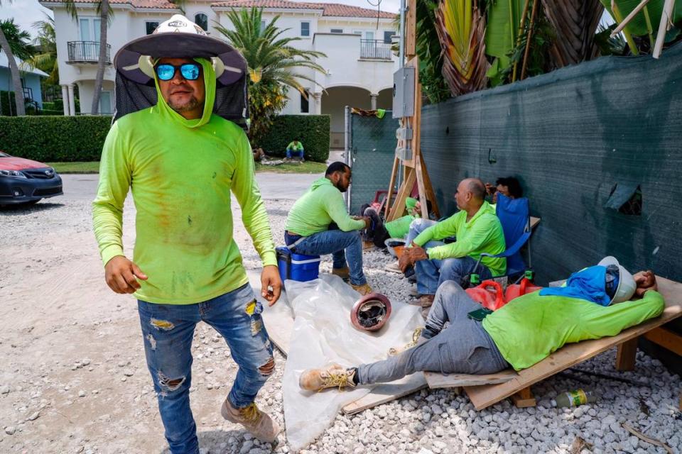 Elvin Murillo and fellow laborers wear protective gear against the hot sun as they take a break at a residential construction site on Key Biscayne, Florida, on May 17, 2024.