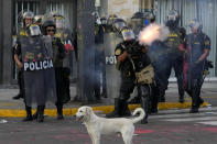 Police fire tear gas at anti-government protesters in Lima, Peru, Tuesday, Jan. 24, 2023. Protesters are seeking the resignation of President Dina Boluarte, the release from prison of ousted President Pedro Castillo, immediate elections and justice for demonstrators killed in clashes with police. (AP Photo/Martin Mejia)