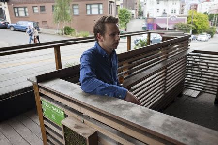 Wyatt O'Day enjoys a beer from an adjacent bar while standing in a public "parklet," which will soon be converted to a "streatery," in Seattle, Washington June 2, 2015. REUTERS/David Ryder