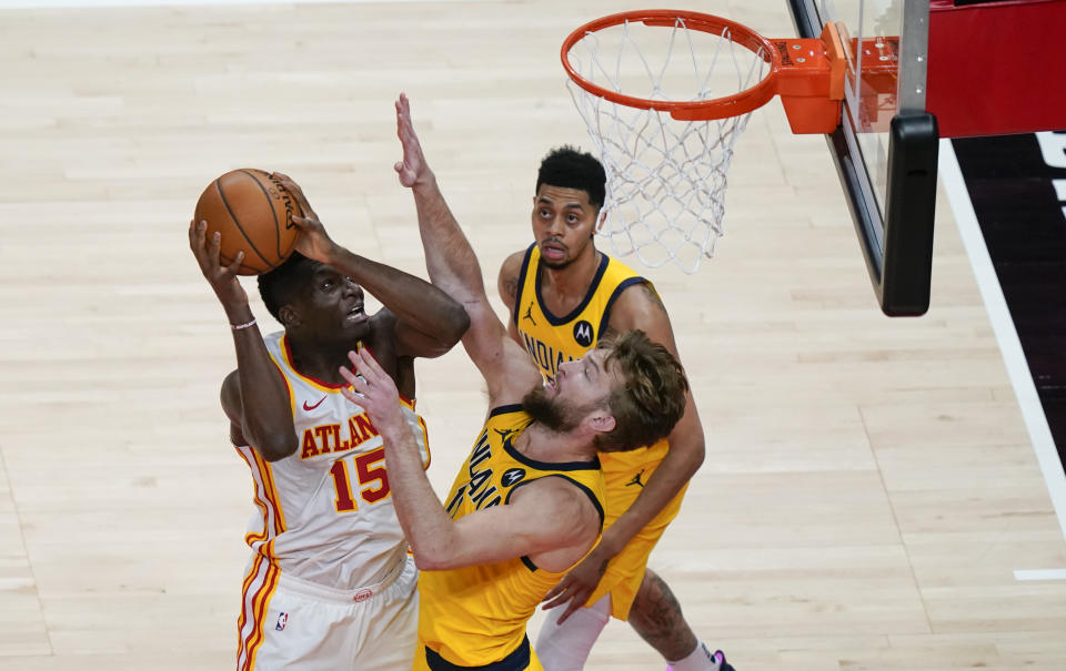 Atlanta Hawks' Clint Capela (15) shoots and scores against Indiana Pacers' Domantas Sabonis (11) during the second half of an NBA basketball game against the Indiana Pacers on Sunday, April 18, 2021, in Atlanta. (AP Photo/Brynn Anderson)