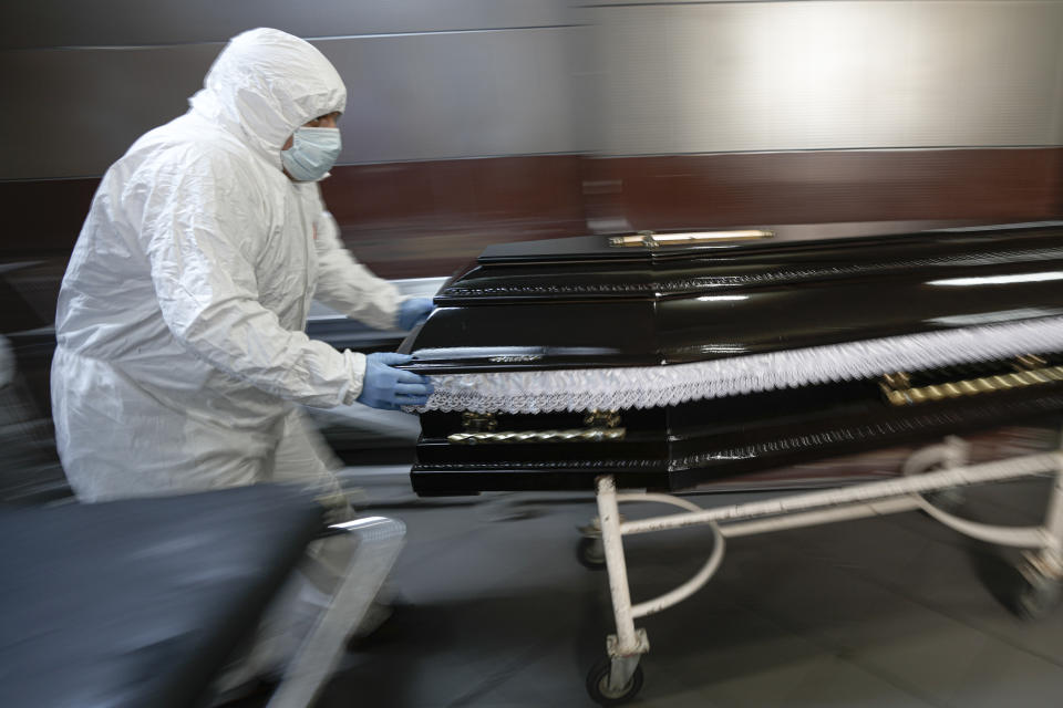 FILE - Funeral house employees drag a coffin on a trolley as they arrive at the University Emergency Hospital morgue to take a COVID-19 victim for burial, in Bucharest, Romania, Monday, Nov. 8, 2021. (AP Photo/Vadim Ghirda, File)