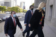 Mark and Patricia McCloskey arrive for a court hearing along with their attorney Joel Schwartz, center, Wednesday, Oct. 14, 2020, in St. Louis. The McCloskeys have pleaded not guilty to two felony charges, unlawful use of a weapon and tampering with evidence, after been seen waving guns at protesters marching on their private street this past summer. (AP Photo/Jeff Roberson)