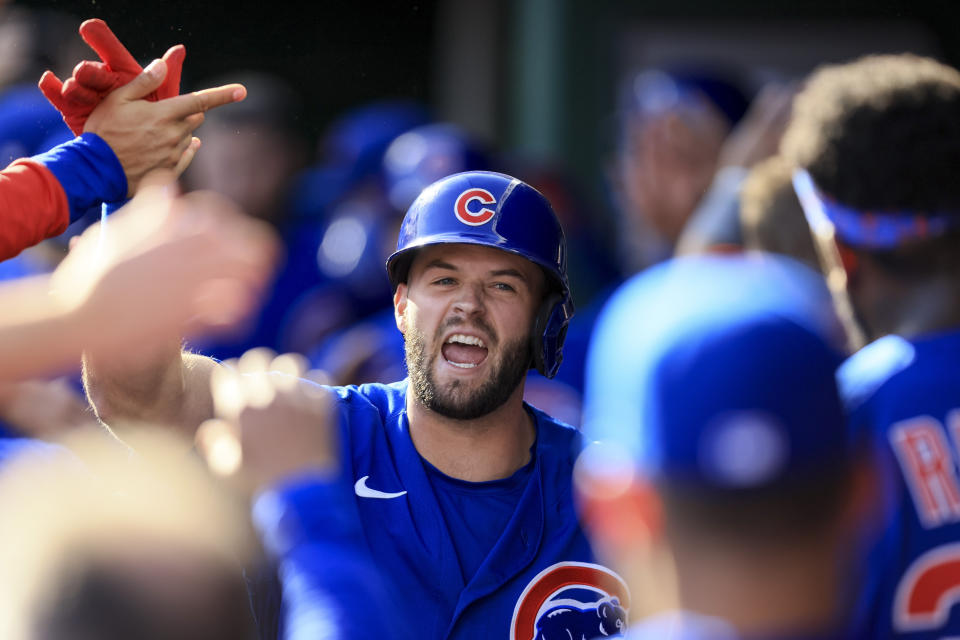 Chicago Cubs' David Bote yells as he high-fives teammates in the dugout after hitting a three-run home run during the second inning of a baseball game against the Cincinnati Reds in Cincinnati, Wednesday, Oct. 5, 2022. (AP Photo/Aaron Doster)