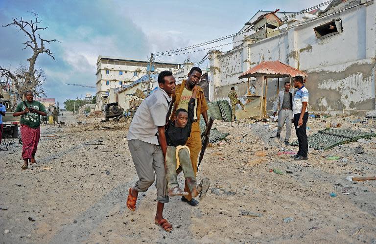 An injured youth is carried away from the scene of a car bomb attack and armed raid by Shebab militants on the Maka al Mukarama hotel in Mogadishu on March 27, 2015