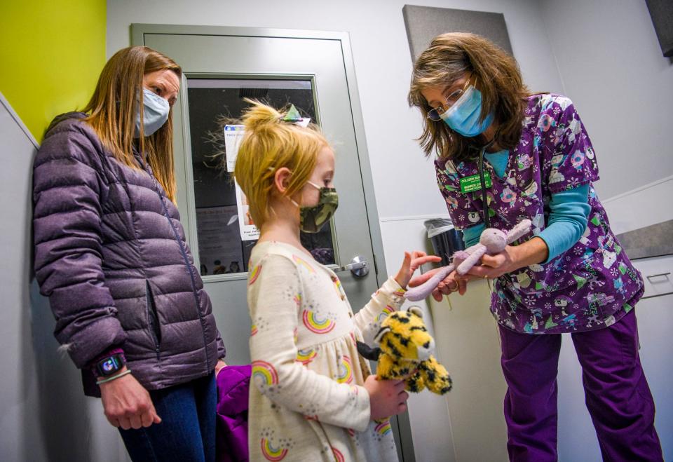 As her mom, Melissa Buchanan, watches Tuesday, Ellie Buchanan points out the problems with Ballerina Bunny to Colleen Seal, a registered veterinary technician, as part of the Stuffy Repair Clinic at the Monroe County Humane Association. One of the main goals of the clinic is to foster the love of animals in young people.