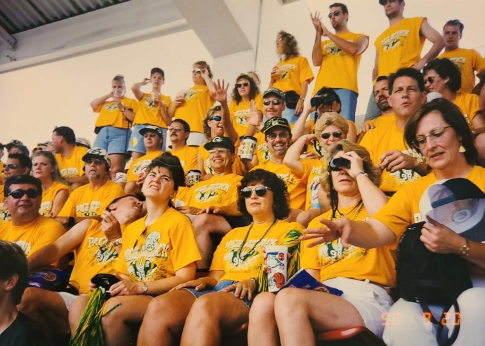 A section of the 320 people who went to Minnesota in the early-to-mid-90s with Dan Bogenschuetz watch the game in their yellow shirts. Bogenschuetz used to design shirts for groups but since stopped because people now tend to already have Packers gear they like to wear.