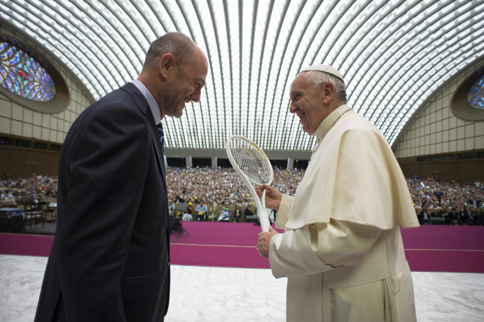 FILE - Pope Francis is presented with a tennis racket by the President of the Italian Tennis Federation Angelo Binaghi, left, during an audience with athletes and members of the federation in the Paul VI hall at the Vatican, Friday, May 8, 2015. Pope Francis congratulated Italy on Monday, Jan. 29, 2024, after tennis player Jannik Sinner became the country's first man to win a Grand Slam singles title, the Australian Open, in nearly a half century. (L'Osservatore Romano/Pool Photo via AP, File)