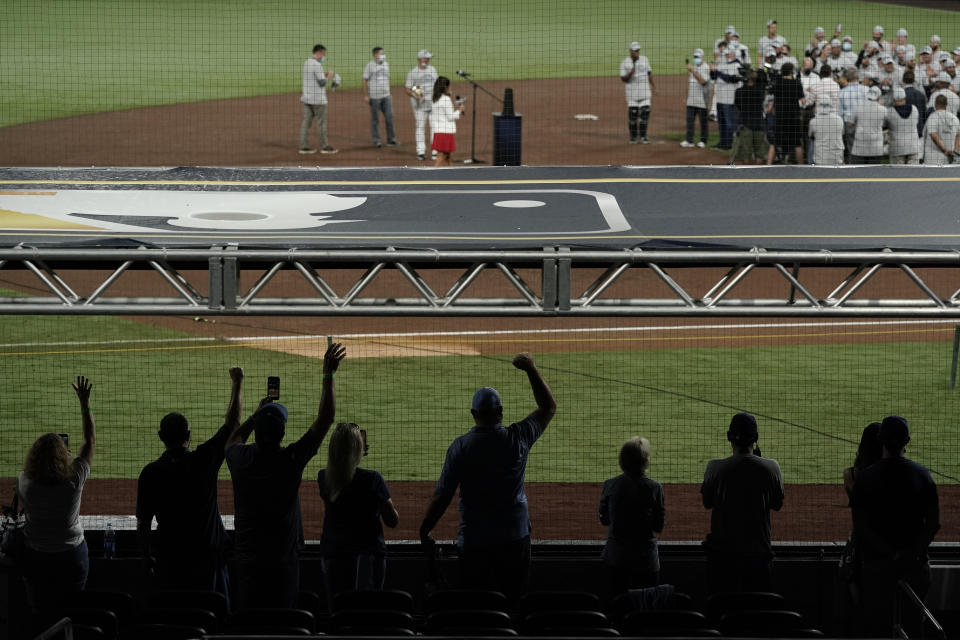 Tampa Bay Rays families celebrate from a distance following the team's victory against the Houston Astros in Game 7 of a baseball American League Championship Series, Saturday, Oct. 17, 2020, in San Diego. The Rays defeated the Astros 4-2 to win the series 4-3 games. (AP Photo/Gregory Bull)