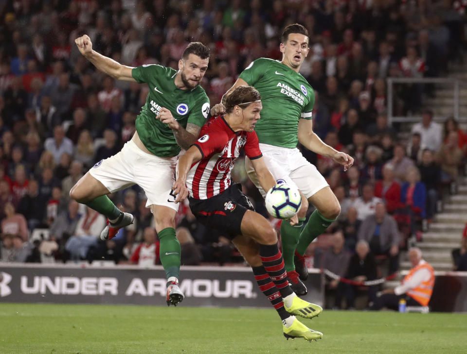 Brighton & Hove Albion's Shane Duffy, left, scores his side's first goal of the game against Southampton during their English Premier League soccer match at St Mary's in Southampton, England, Monday Sept. 17, 2018. (John Walton/PA via AP)