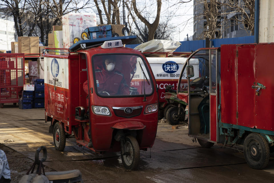 In this Tuesday, Feb. 18, 2020, photo, a delivery worker for Chinese e-commerce giant JD.com leaves with the morning load of parcels from a distribution center in Beijing, China. JD and rivals including Pinduoduo, Miss Fresh and Alibaba Group's Hema are scrambling to fill a boom in orders while protecting their employees. E-commerce is one of the few industries to thrive after anti-virus controls starting in late January closed factories, restaurants, cinemas, offices and shops nationwide and extinguished auto and real estate sales. (AP Photo/Ng Han Guan)