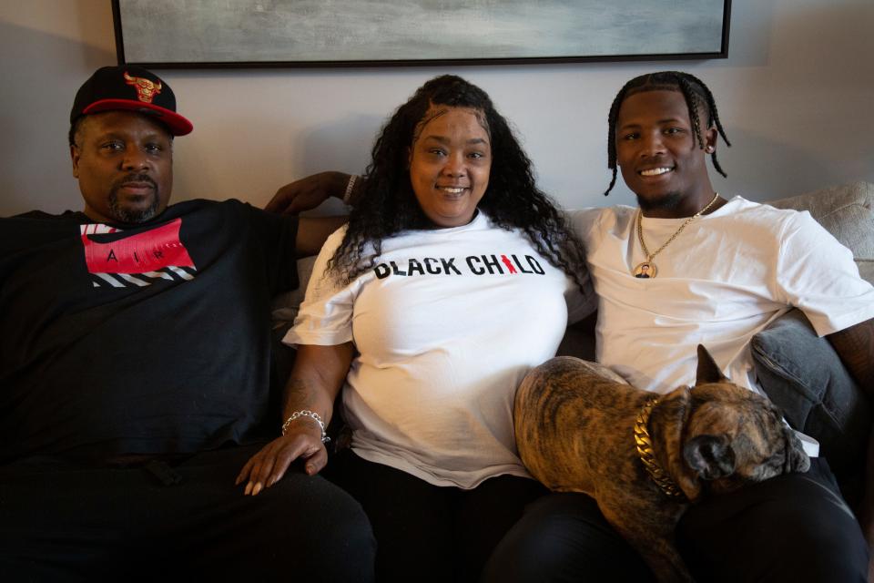 Cincinnati Bengals receiver Tee Higgins (right) sits on the couch with his parents Eric Higgins and Lady Stewart and his dog Cinco at their home in Knoxville, Tennessee, in June.