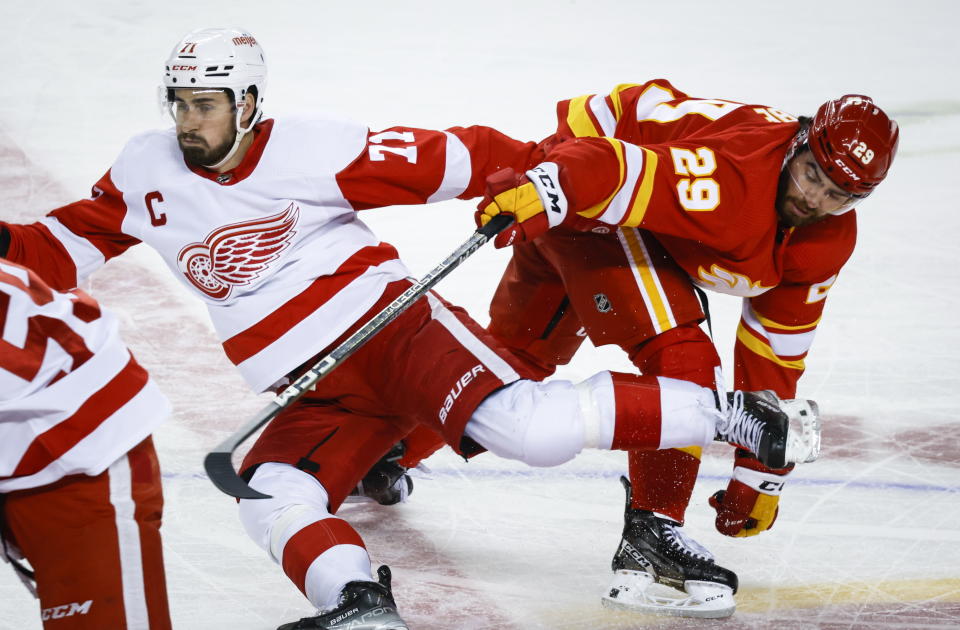 Detroit Red Wings forward Dylan Larkin, left, is checked by Calgary Flames forward Dillon Dube during second-period NHL hockey game action in Calgary, Alberta, Thursday, Feb. 16, 2023. (Jeff McIntosh/The Canadian Press via AP)