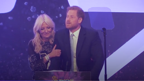 A photo of Britain's Prince Harry, Duke of Sussex tears up on stage alongside television presenter Gaby Roslin as he delivers a speech during the annual WellChild Awards in London on October 15, 2019.