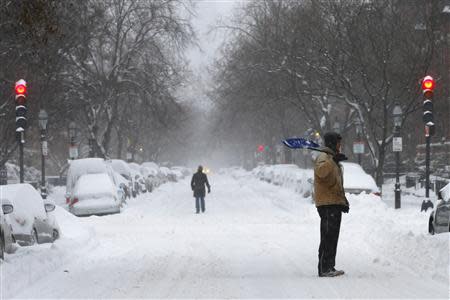 A shoveler stands on Marlborough Street during a winter nor'easter snow storm in Boston, Massachusetts January 3, 2014. REUTERS/Brian Snyder