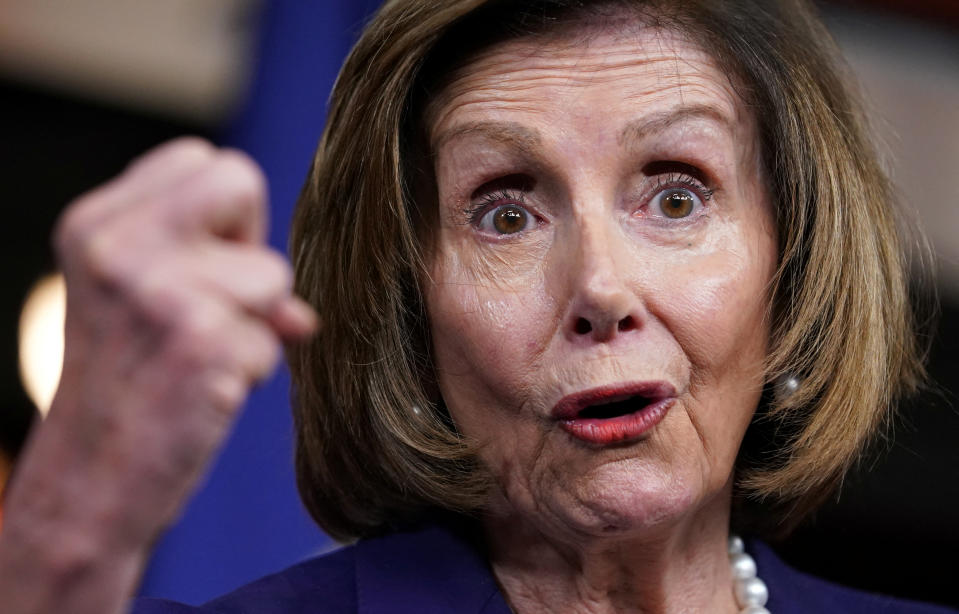 Rep. Nancy Pelosi, raising her fist, vehemently makes a point.