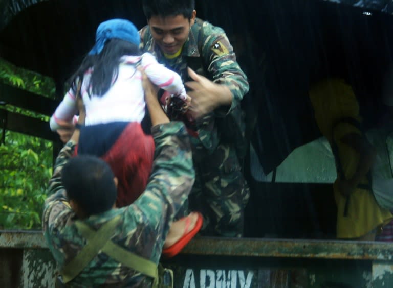 Military personnel evacuate residents from a village south of Manila on December 14, 2015