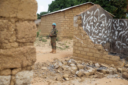 FILE PHOTO: A Bangladeshi United Nations peacekeeping soldier stands among houses destroyed by violence in September, in the abandoned village of Yade, Central African Republic April 27, 2017. Picture taken April 27, 2017. REUTERS/Baz Ratner/File Photo