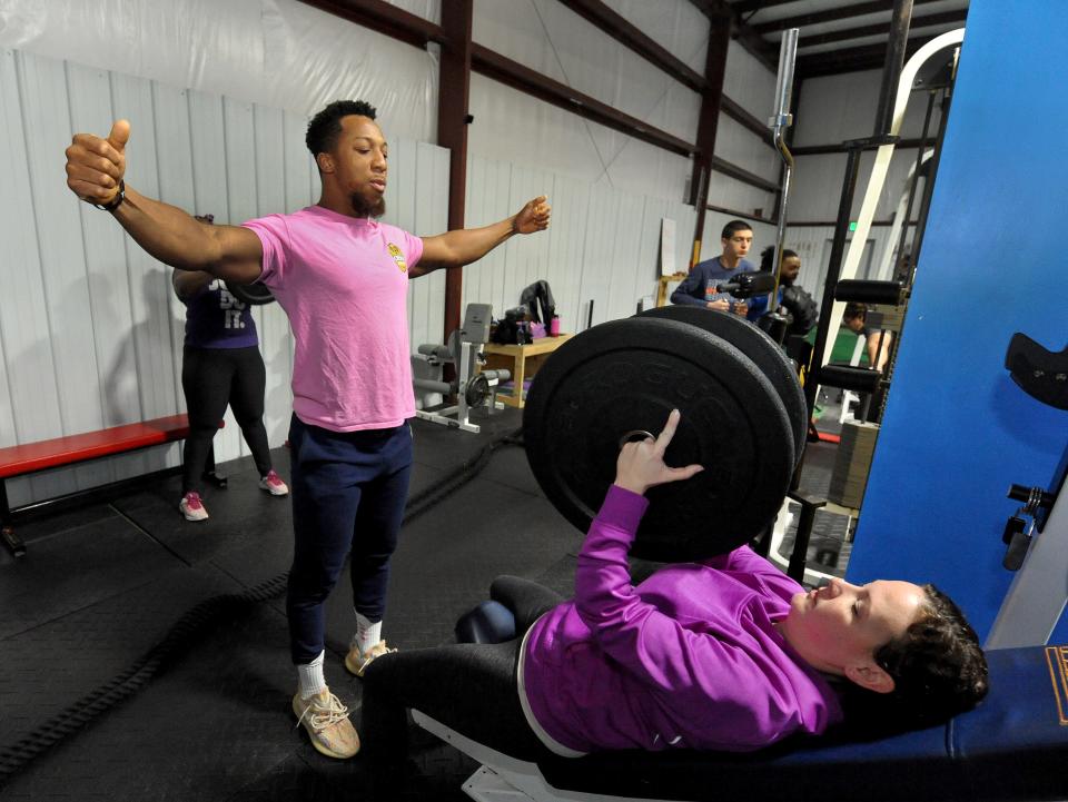 Owner of Creme De La Clem, Clemence Ahiable, wwner of Creme De La Clem, instructs Krystin Townsend of Springfield on how to do chest flies during class on March 8. [Thomas J. Turney/The State Journal-Register]