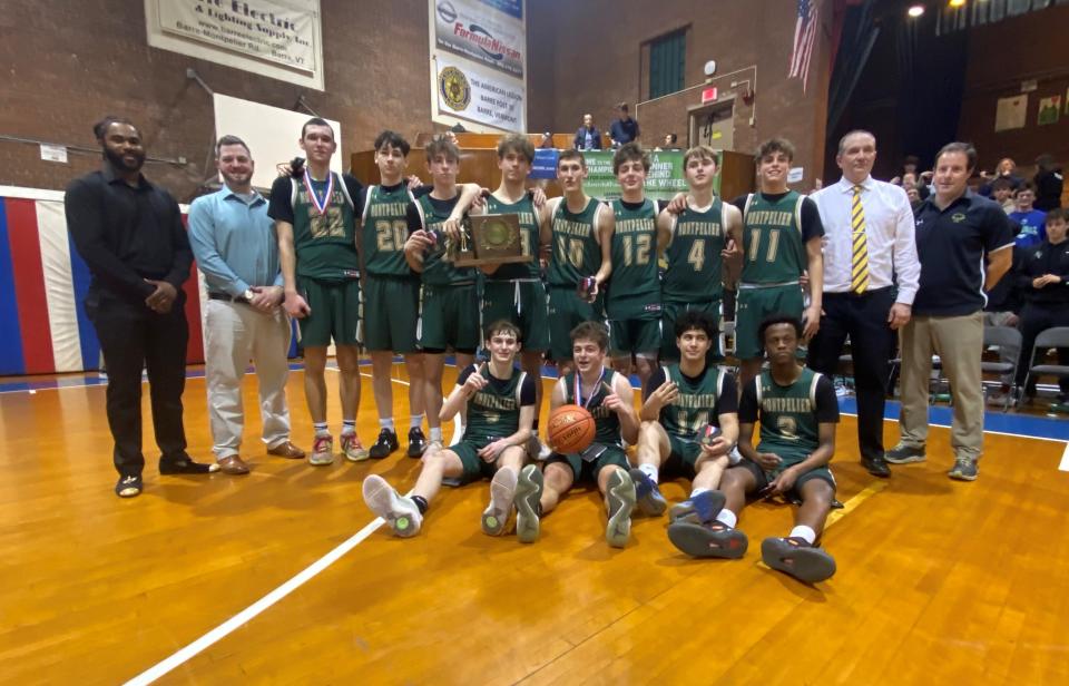 The Montpelier High School boys basketball poses with the Division II trophy after securing a championship four-peat with a 58-49 win over No. 1 Hartford at Barre Auditorium on Saturday, March 2, 2024.