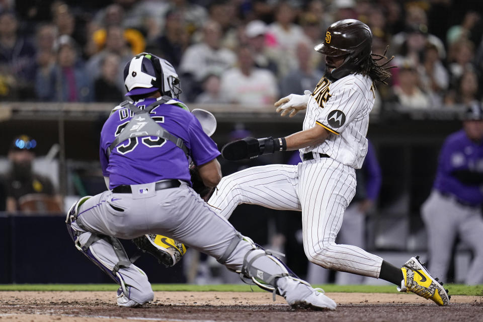 San Diego Padres' Fernando Tatis Jr., right, is tagged out by Colorado Rockies catcher Elias Diaz, trying to score off a fielder's choice by Luis Campusano during the eighth inning of a baseball game Tuesday, Sept. 19, 2023, in San Diego. (AP Photo/Gregory Bull)