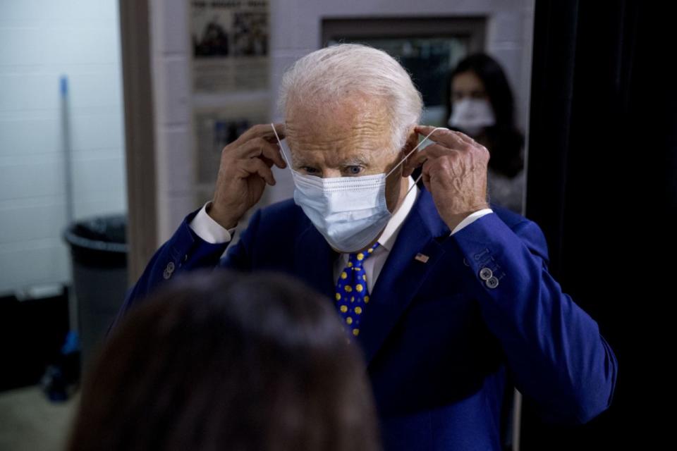 El candidato presidencial demócrata y exvicepresidente Joe Biden se coloca la mascarilla a su salida de un acto de campaña en el Centro Comunitario William "Hicks" Anderson en Wilmington, Delaware, el martes, 28 de julio de 2020 (AP Photo / Andrew Harnik).