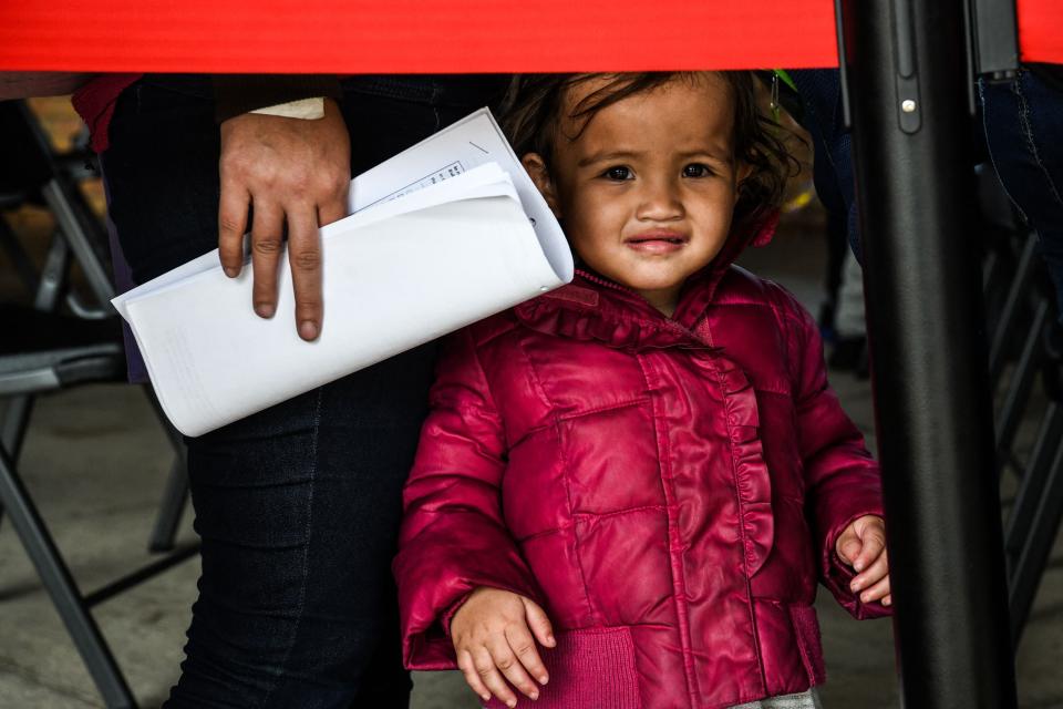 A migrant girl from Central America waits with her mother for a bus after they are dropped off by the U.S. Customs and Border Protection at a bus station near the Gateway International Bridge, between the cities of Brownsville, Texas, and Matamoros, Mexico, on March 15. (Photo: Chandan Khanna/Getty Images)