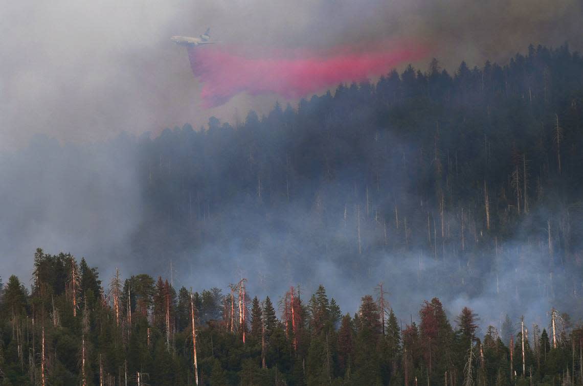 An air tanker drops fire-retardant chemicals on the Washburn Fire as it burns in late afternoon light near the south entrance of Yosemite National Park Saturday, July 9, 2022 near Fish Camp.