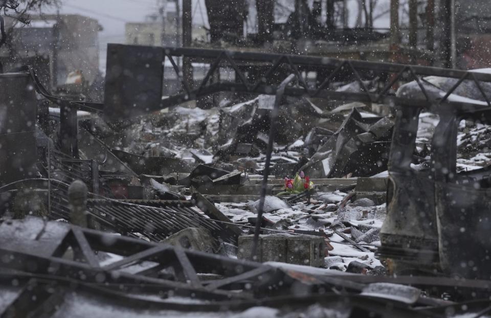 Tulips are placed on the rubble of fallen buildings, at a marketplace in Wajima, Ishikawa prefecture, Sunday, Jan. 7, 2024. The large fire burnt out the marketplace and houses in the city, following the earthquakes. Rescue teams worked through snow to deliver supplies to isolated hamlets Monday, a week after a powerful earthquake hit western Japan. (Kyodo News via AP)