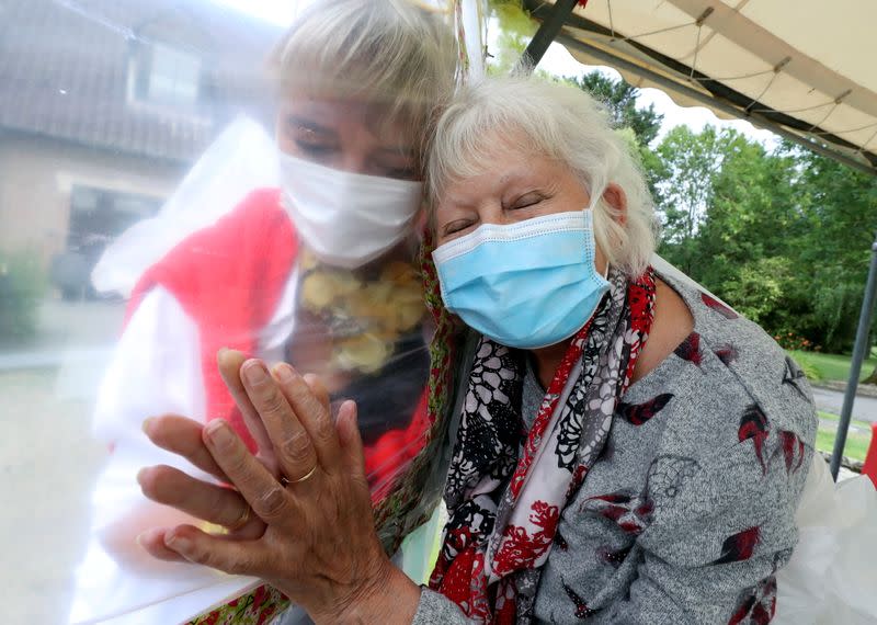 FOTO DE ARCHIVO. Lily Hendrickx, de 83 años, residente en el hogar de ancianos belga "Le Jardin de Picardie" disfruta de abrazos y mimos con Marie-Christine Desoer, la directora de la residencia, a través de una pared hecha con láminas de plástico para protegerse contra una posible infección de la enfermedad coronavirus (COVID-19), en Peruwelz, Bélgica