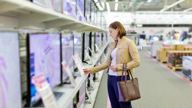 woman chooses a TV in the store.