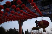 A worker dismantles decorations after the temple fair for the Chinese Lunar New Year in Ditan Park was canceled in Beijing