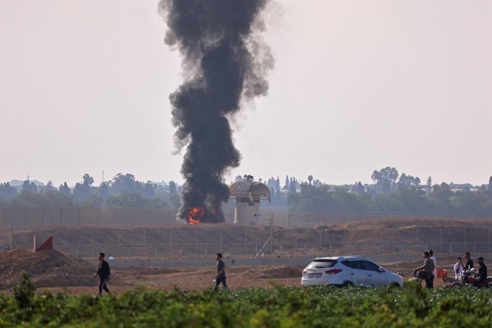 A picture taken from Khan Yunis in the southern Gaza Strip shows smoke billowing next to an Israeli observation tower on Oct. 7, 2023.