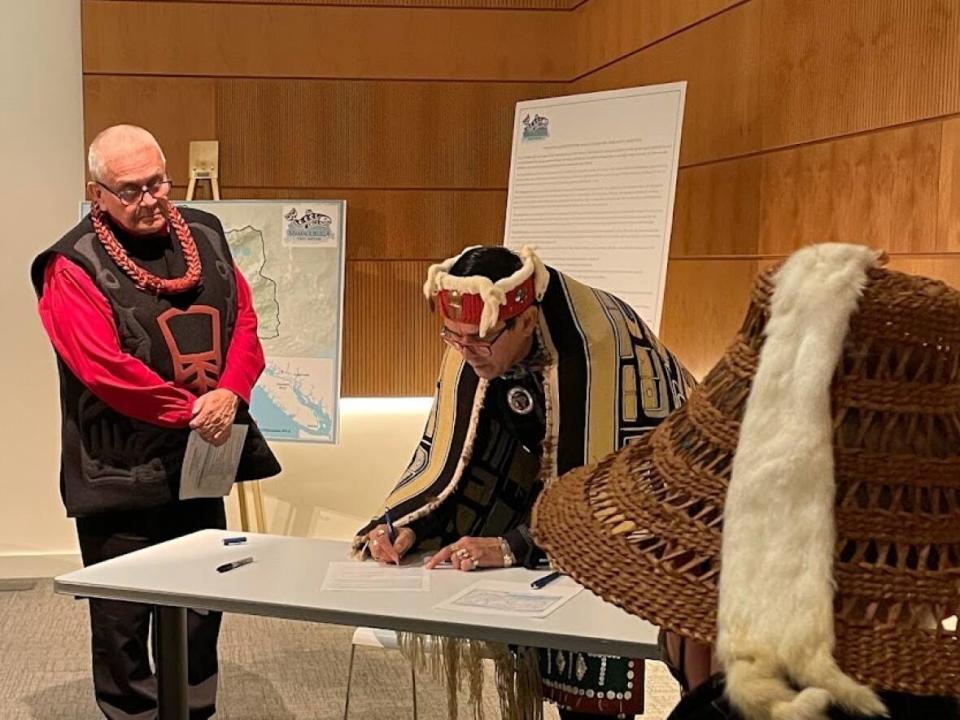 Mamalilikulla Chief John Powell signs the IPCA declaration. (Liz McArthur/CBC - image credit)