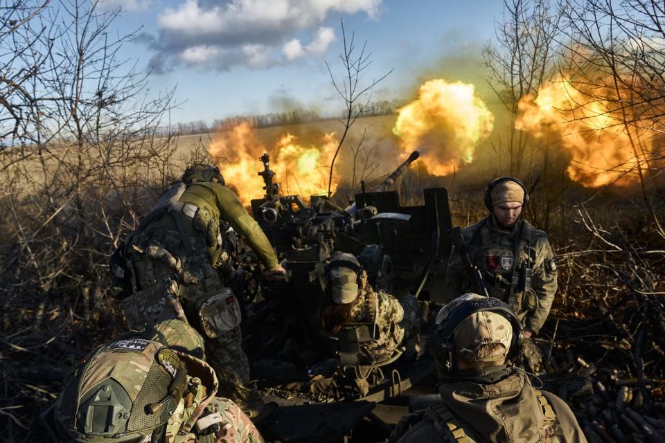 Ukrainian soldiers fire an AZP S-60 from between trees near Bakhmut