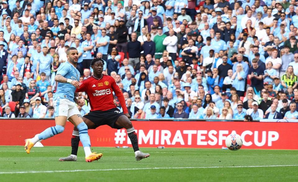 Kobbie Mainoo slides home United’s second goal (Reuters)