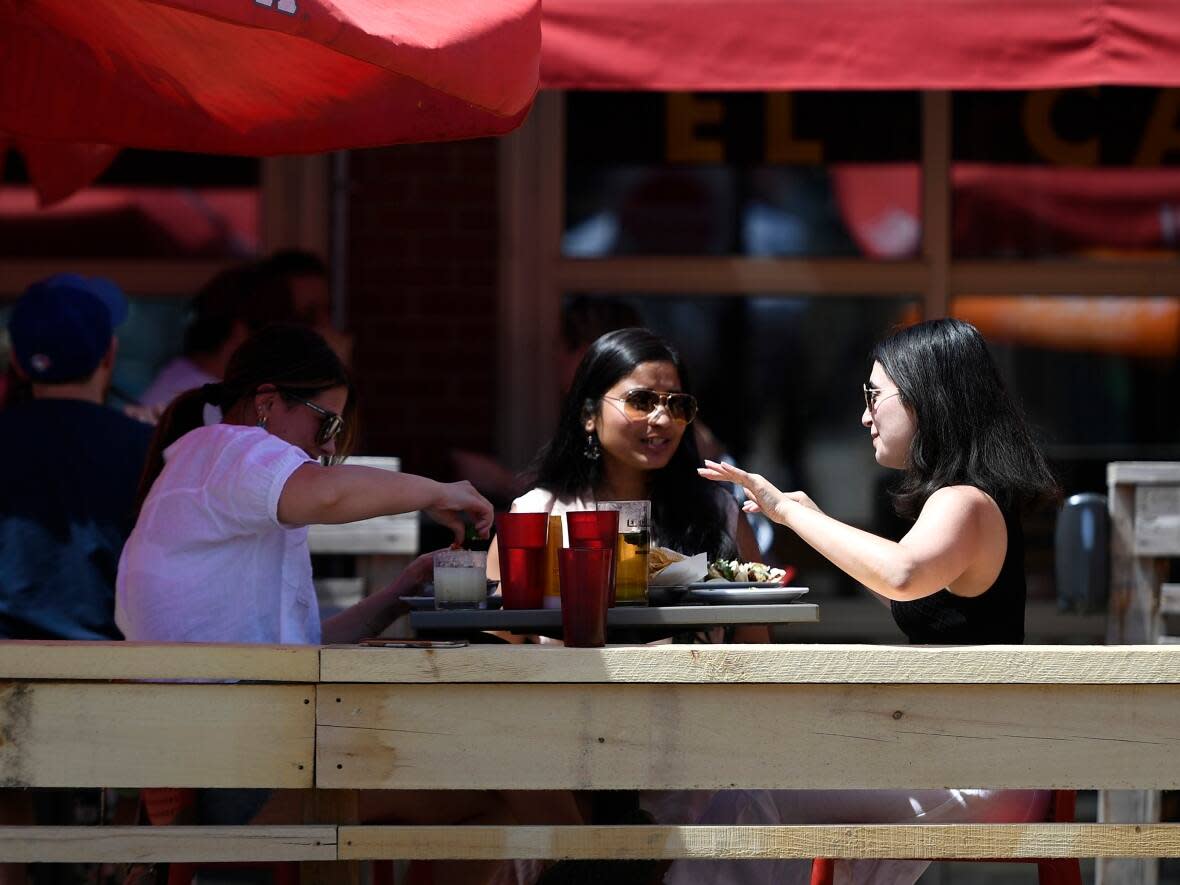 A draft by-law seeks to make permanent some changes meant to offset impacts restaurants  faced during the pandemic: including one that would allow patios on sidewalks, on-street parking spaces and roadways to remain open until 2 a.m.  (Justin Tang/The Canadian Press - image credit)