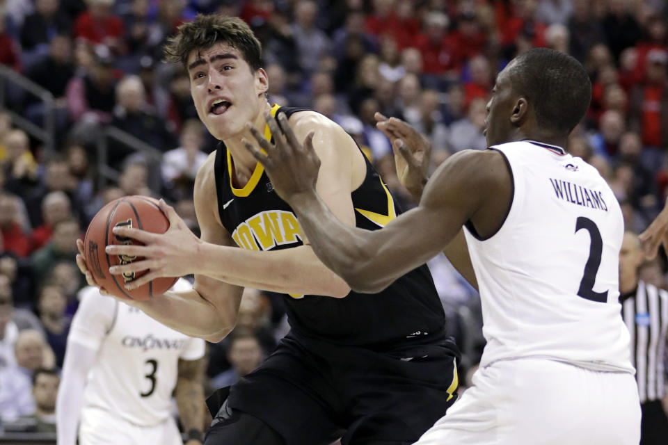 FILE - In this March 22, 2019, file photo, Iowa's Luka Garza (55) drives past Cincinnati's Keith Williams (2) in the second half during a first-round men's college basketball game in the NCAA Tournament in Columbus, Ohio. Returning starters Joe Wieskamp and Luka Garza headline a roster that is deep at every position. (AP Photo/Tony Dejak, File)