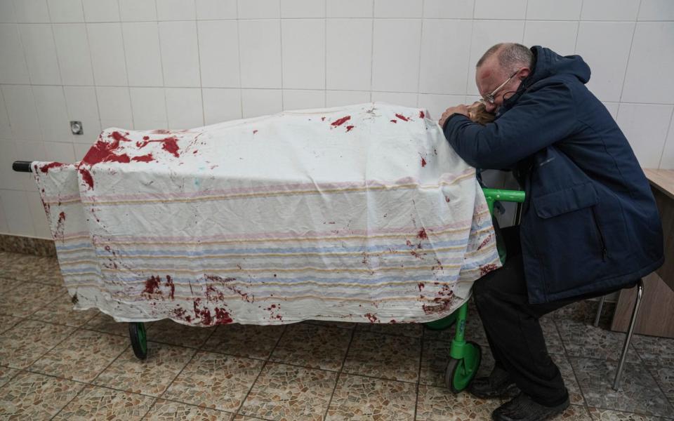 Serhii, father of teenager Iliya, cries on his son's lifeless body lying on a stretcher at a maternity hospital converted into a medical ward in Mariupol, Ukraine, Wednesday, March 2, 2022. - AP Photo/Evgeniy Maloletka
