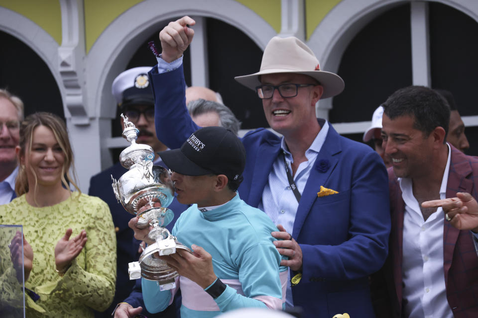 RETRANSMISSION TO CORRECT NAME OF AWARD TO WOODLAWN VASE - Jockey John Velazquez, center, kisses the Woodlawn Vase while standing with Tom Ryan, second from right, of SF Bloodstock, after winning the148th running of the Preakness Stakes horse race at Pimlico Race Course, Saturday, May 20, 2023, in Baltimore. (AP Photo/Julia Nikhinson)