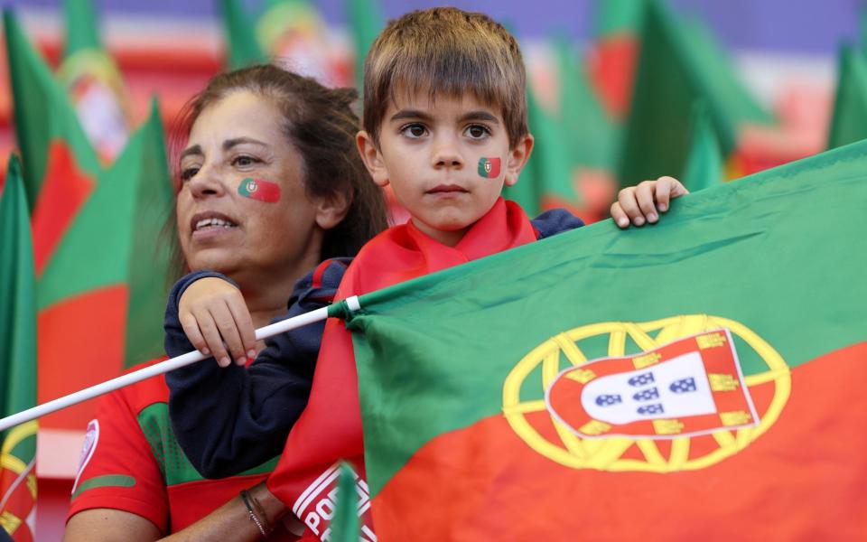 LEIGH, ENGLAND - JULY 09: Fans of Portugal look on whilst holding a flag prior to the UEFA Women's Euro 2022 group C match between Portugal and Switzerland at Leigh Sports Village on July 09, 2022 in Leigh, England. - Charlotte Tattersall/UEFA