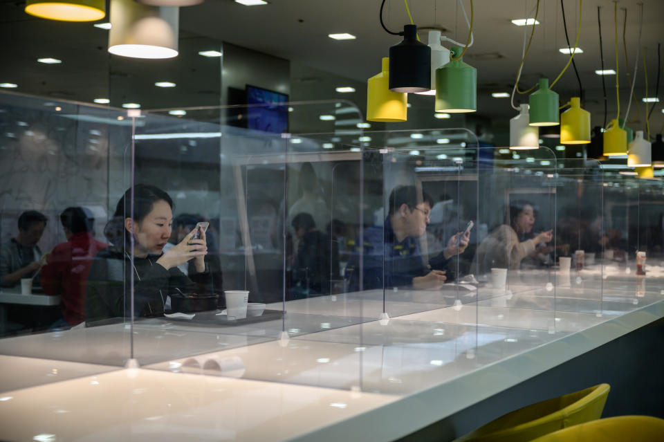 Empleados de la tarjeta de crédito de Hyundai en la cafetería de la empresa, separados por pantallas protectoras (ED JONES/AFP via Getty Images)