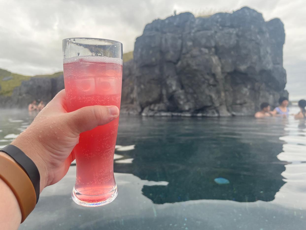 megan holding up a lemonade while soaking in sky lagoon